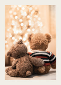 Two teddy bears from behind against bright Christmas tree, soft colors-3