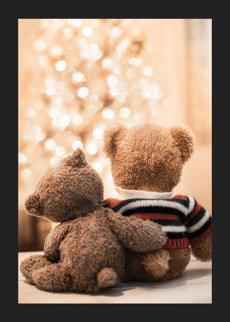 Two teddy bears from behind against bright Christmas tree, soft colors-12