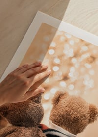 Two teddy bears from behind against bright Christmas tree, soft colors-9