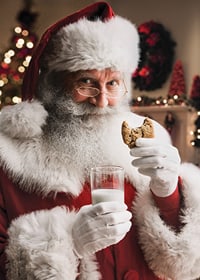 Jultomte med glas mjölk och chokladkaka i julmiljö-7