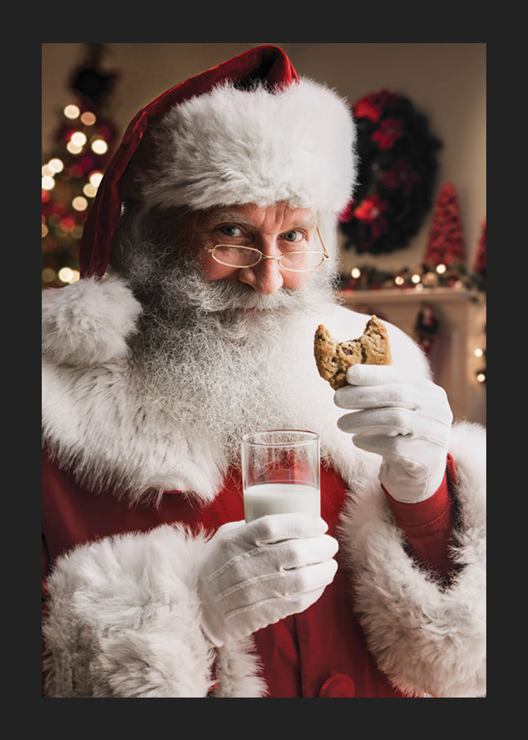 Jultomte med glas mjölk och chokladkaka i julmiljö-12
