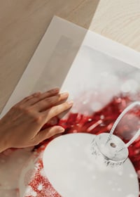 Närbild av röd och vit julkula med glitter och renmotiv-9