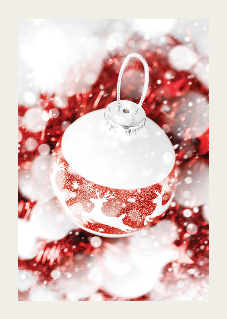 Närbild av röd och vit julkula med glitter och renmotiv-12