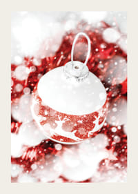 Närbild av röd och vit julkula med glitter och renmotiv-3