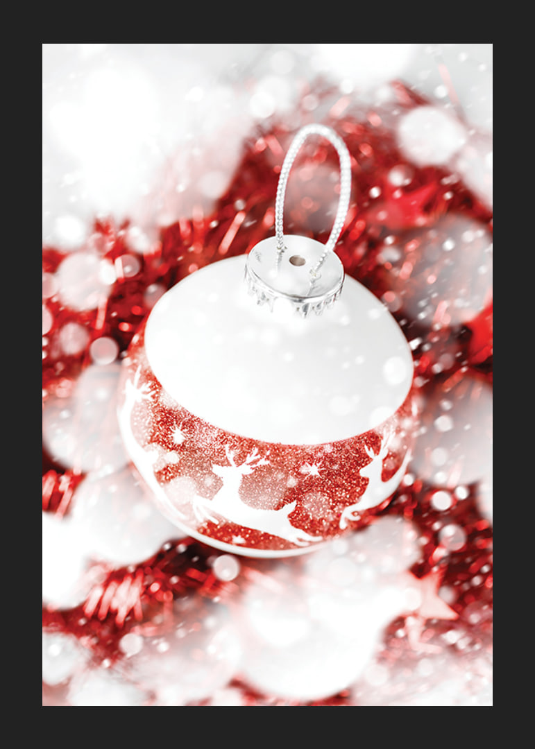 Närbild av röd och vit julkula med glitter och renmotiv-12