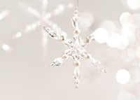 Close-up of sparkling crystal snowflake decoration against light background-7