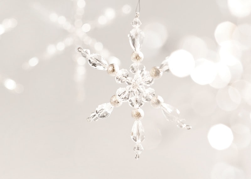 Close-up of sparkling crystal snowflake decoration against light background-12