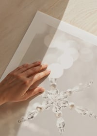 Close-up of sparkling crystal snowflake decoration against light background-9