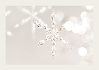 Close-up of sparkling crystal snowflake decoration against light background-3