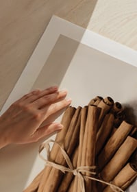 Akvarell av bunt kanelstänger knutna med snöre i varma toner-9