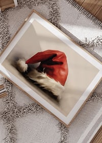 Watercolor of red Santa hat with white border on light background-8