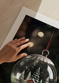 Photograph of snow globe with red cottage and fir trees in Christmas tree-9