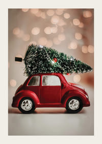 Voiture jouet rouge avec un sapin de Noël sur le toit sur un fond de lumière floue-3