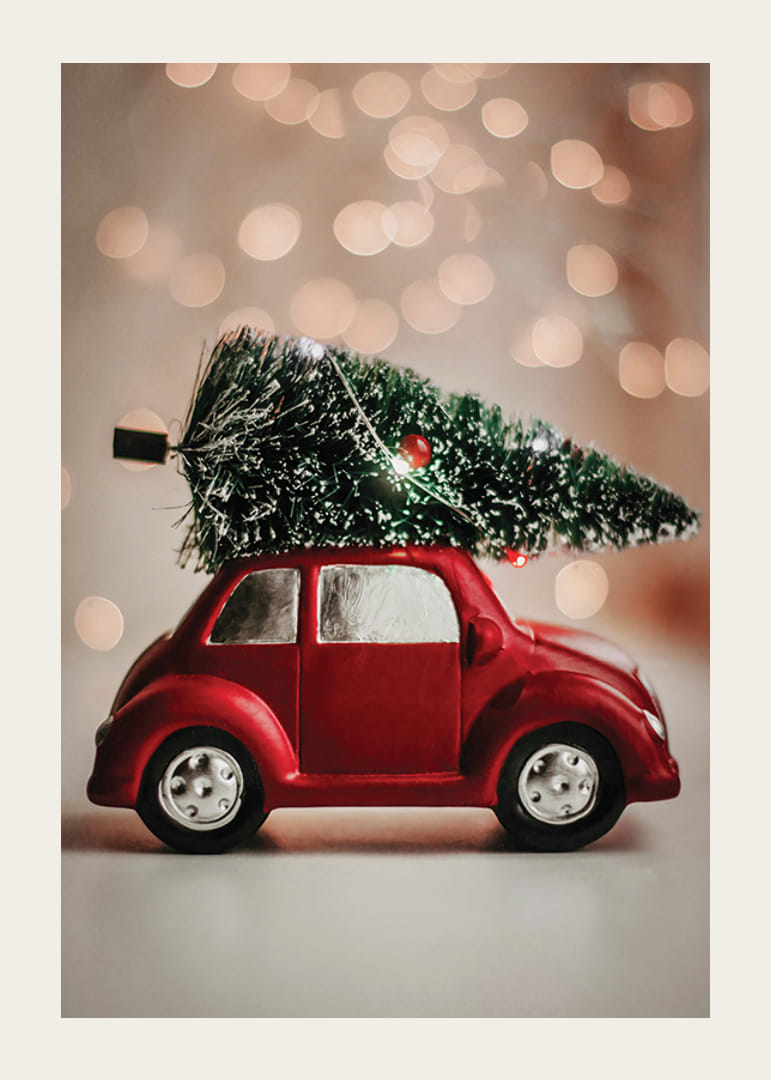 Voiture jouet rouge avec un sapin de Noël sur le toit sur un fond de lumière floue-12