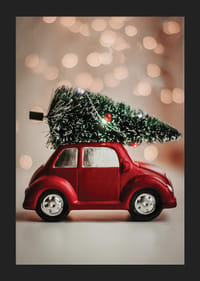 Voiture jouet rouge avec un sapin de Noël sur le toit sur un fond de lumière floue-5