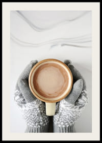 Gråstickade vantar håller kopp med varm choklad, ovanifrån-2