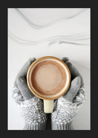 Gråstickade vantar håller kopp med varm choklad, ovanifrån-5