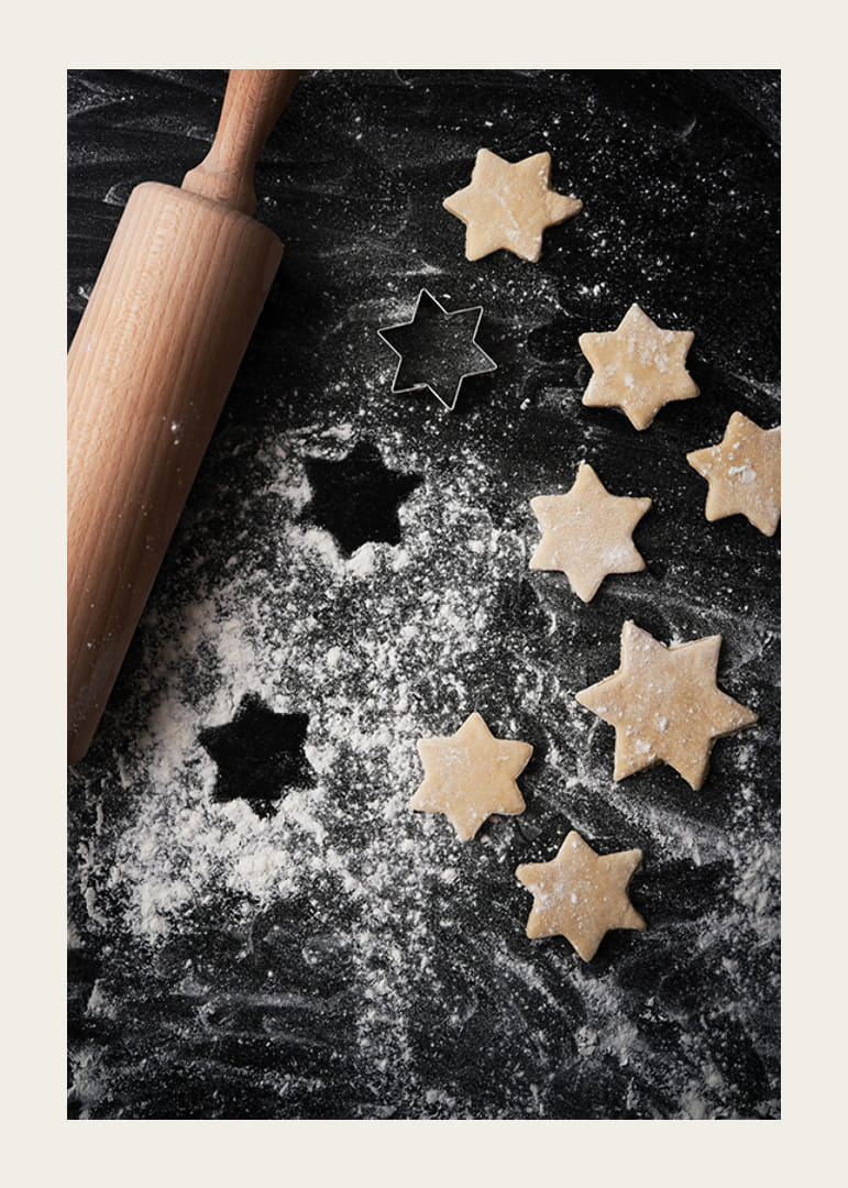 Fotografia rozvaľkaného cesta, valčeka a vykrajovačky na sušienky v tvare hviezdy na pomúčenom stole-12