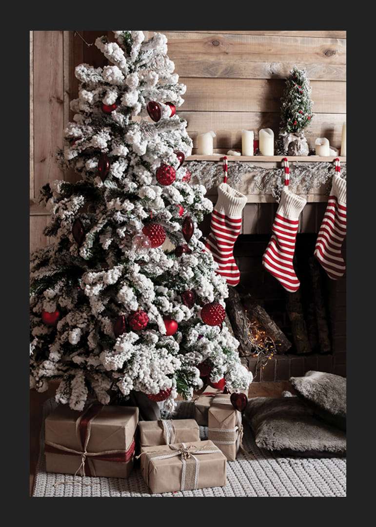 Zasnežená jedľa s červenými guľami, vianočnými darčekmi a pruhovanými ponožkami-12