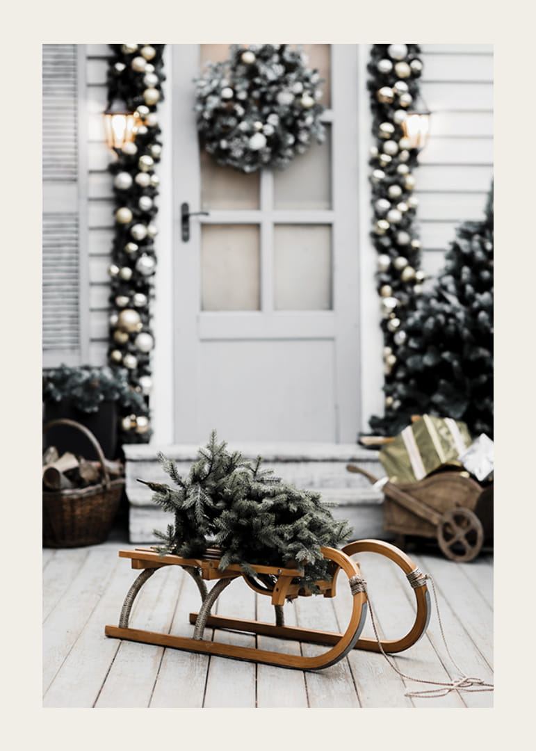 Zdjęcie jodły na drewnianych saniach przed ozdobionymi drzwiami-12