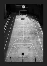 Black and white photo of empty basketball court with sharp lines and shadows-1