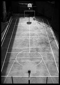 Black and white photo of empty basketball court with sharp lines and shadows-6