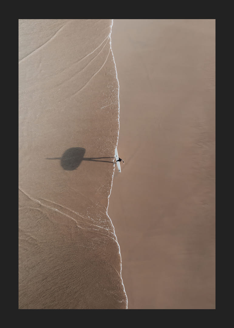 Aerial view of lone surfer with board on sandy beach-12