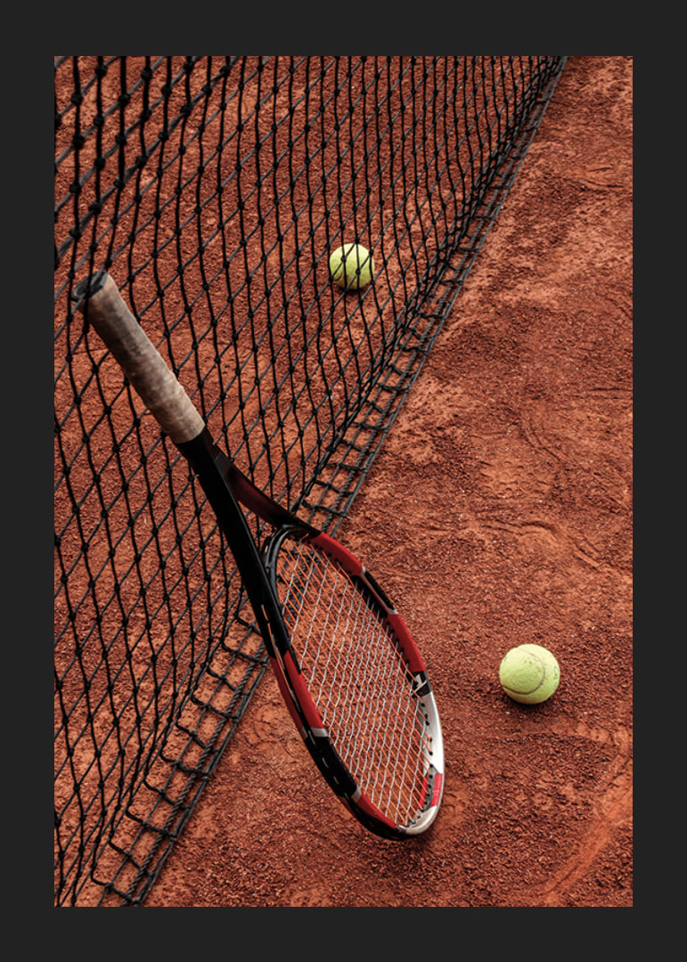 Fotografiskt motiv med tennisracket och bollar på grusplan-12