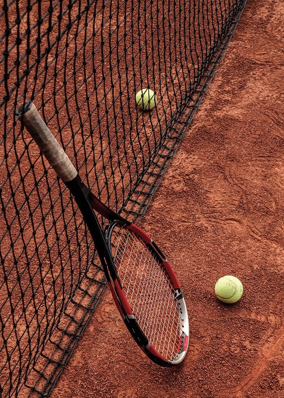 Fotografiskt motiv med tennisracket och bollar på grusplan-12