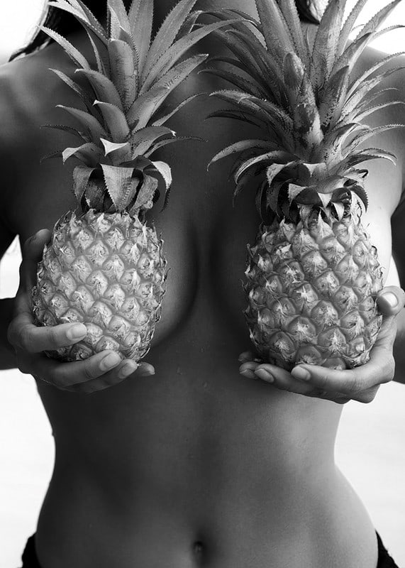 Black and white photo of woman holding two pineapples to her chest-12