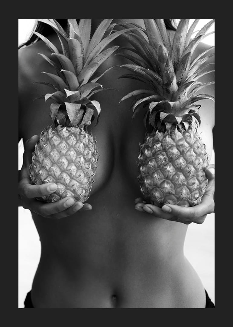 Black and white photo of woman holding two pineapples to her chest-12