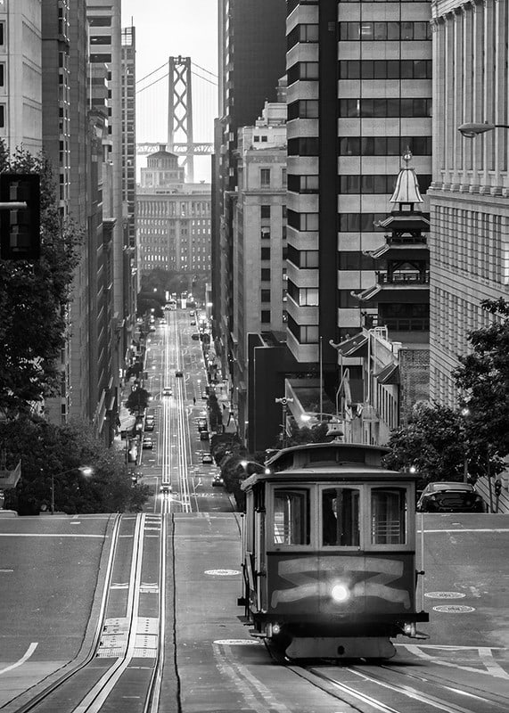 Svartvit stadsvy med spårvagn i San Francisco och bro i bakgrunden-12