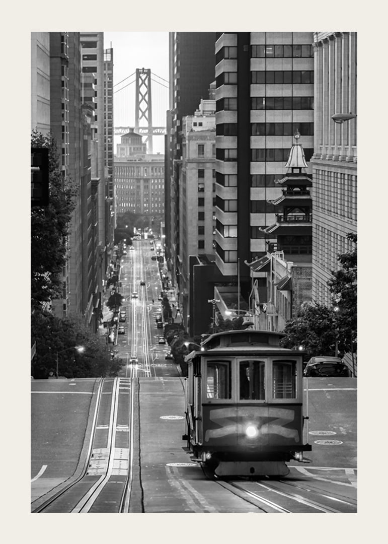 Svartvit stadsvy med spårvagn i San Francisco och bro i bakgrunden-12