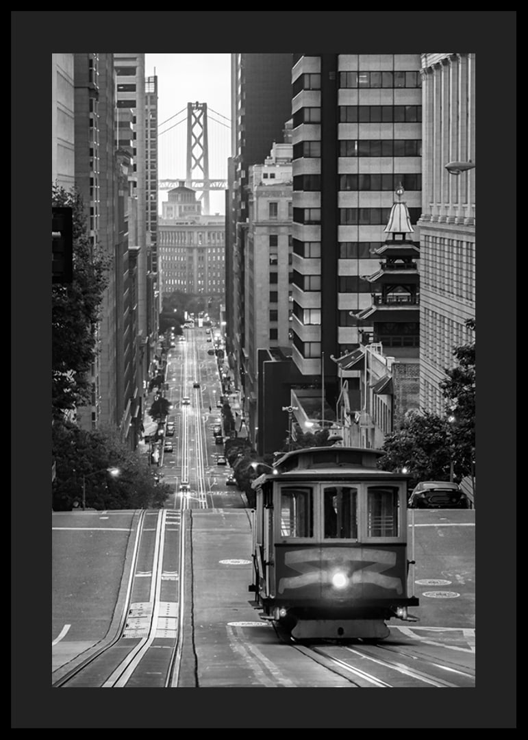 Svartvit stadsvy med spårvagn i San Francisco och bro i bakgrunden-12