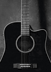 Black and white close-up of acoustic guitar against concrete background-7