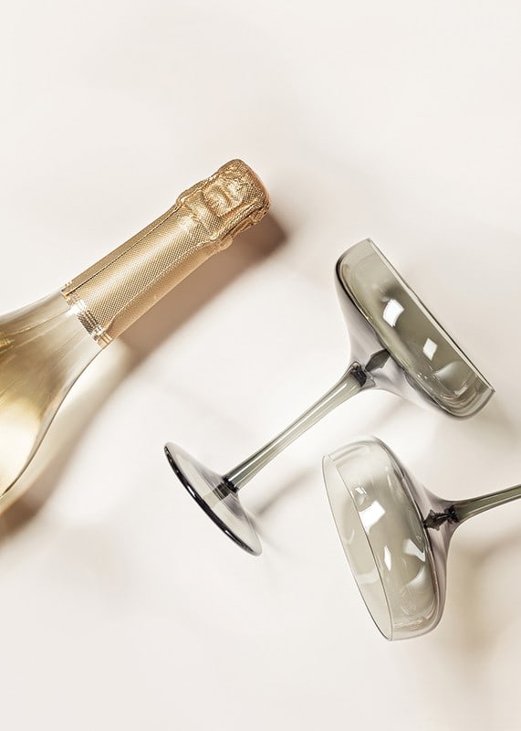 Champagnerflasche und zwei Gläser vor hellem Hintergrund, fotografisch-12