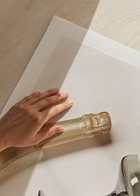 Champagnerflasche und zwei Gläser vor hellem Hintergrund, fotografisch-9