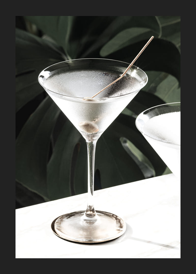 Photographic close-up of martini glass with olive and iced surface-12