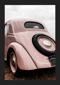 Photograph of classic pink vintage car in grass, rear view-5
