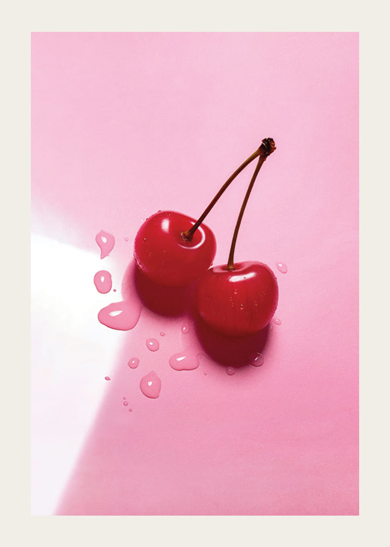 Två röda cocktailbär med stjälkar på blank rosa yta-12