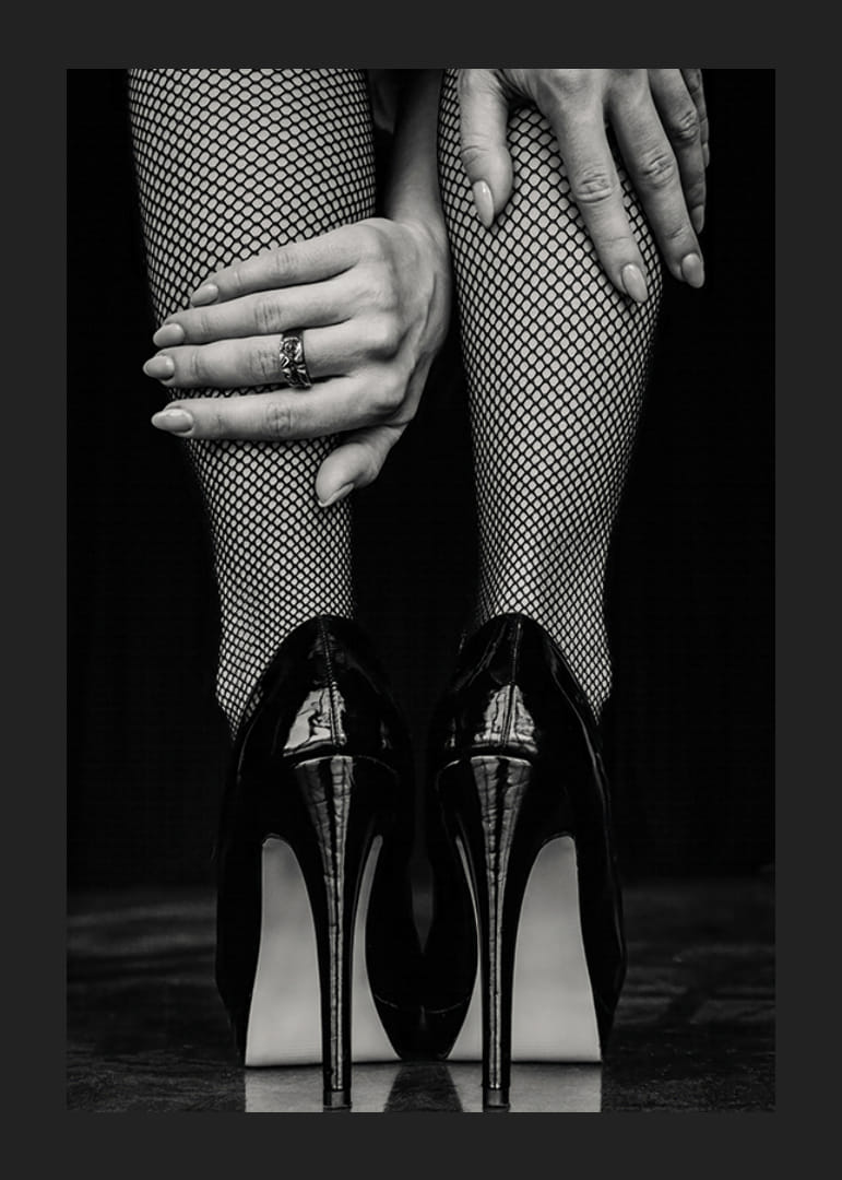 Black and white photo of legs in fishnet tights and black heels-12