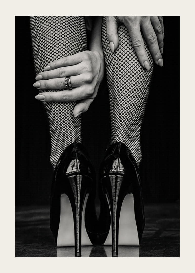 Black and white photo of legs in fishnet tights and black heels-12