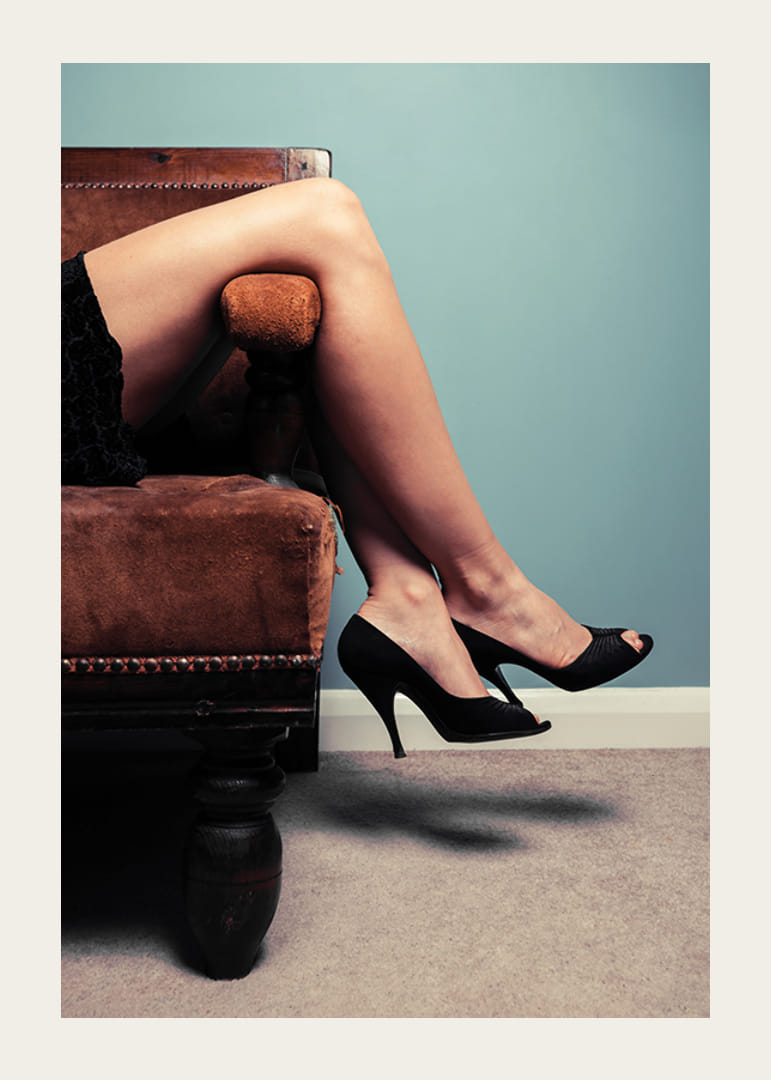 Gros plan photographique d'une femme en talons hauts sur un canapé-12