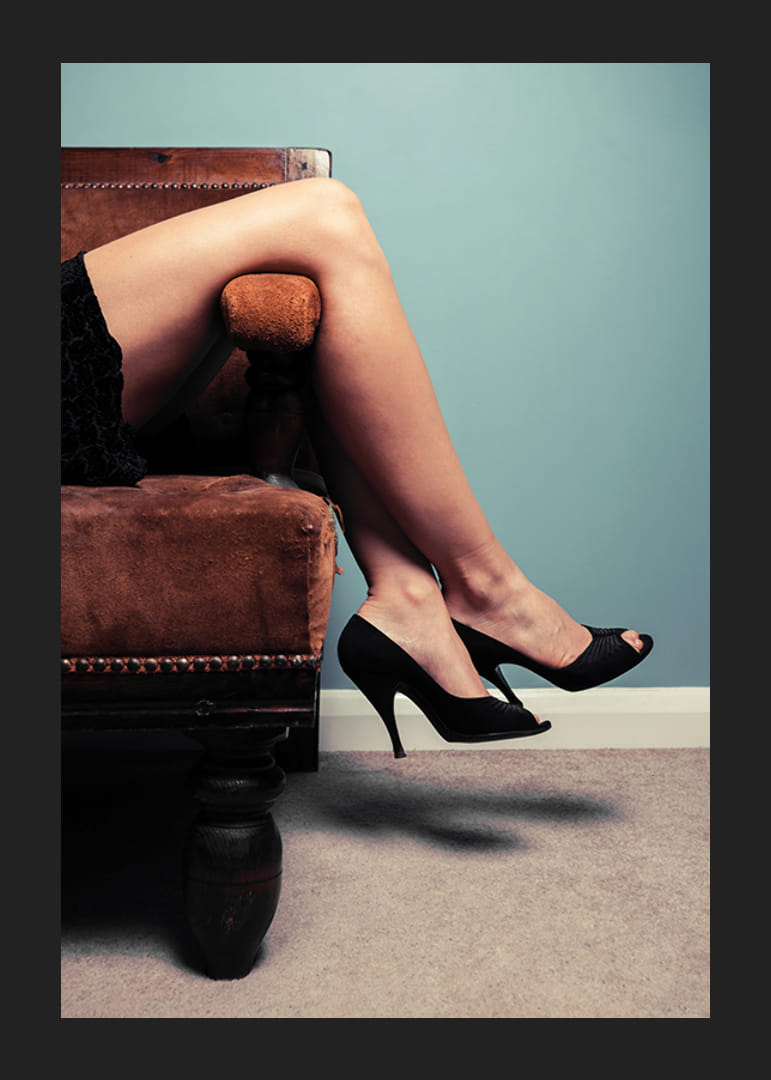 Gros plan photographique d'une femme en talons hauts sur un canapé-12