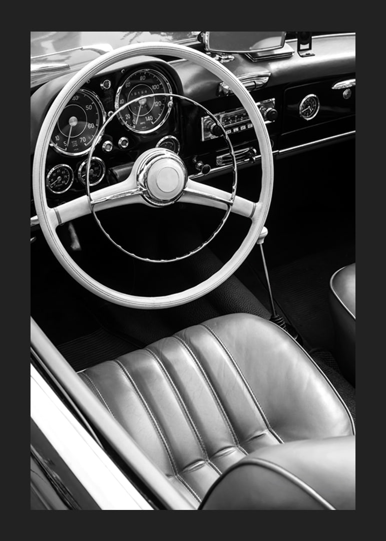 Black and white close-up of classic car interior with steering wheel-12