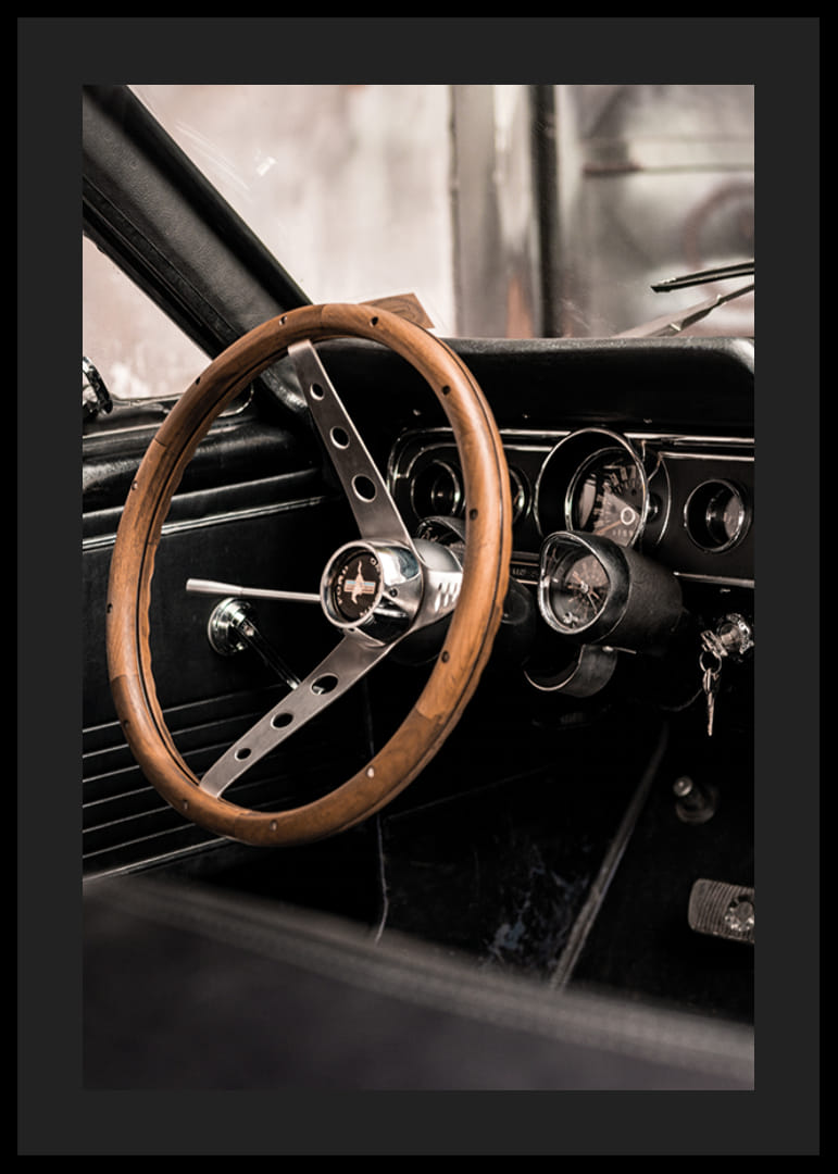 Fotografía del interior de un coche clásico con un volante de madera enfocado.-12