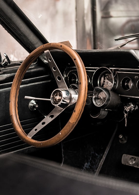 Photograph of classic car interior with wooden steering wheel in focus-12