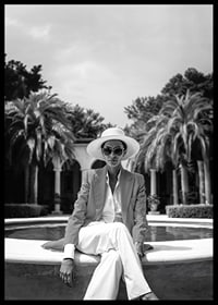 Black and white photo of woman in suit and sun hat by pool-6
