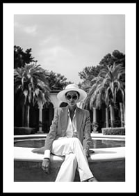 Black and white photo of woman in suit and sun hat by pool-0