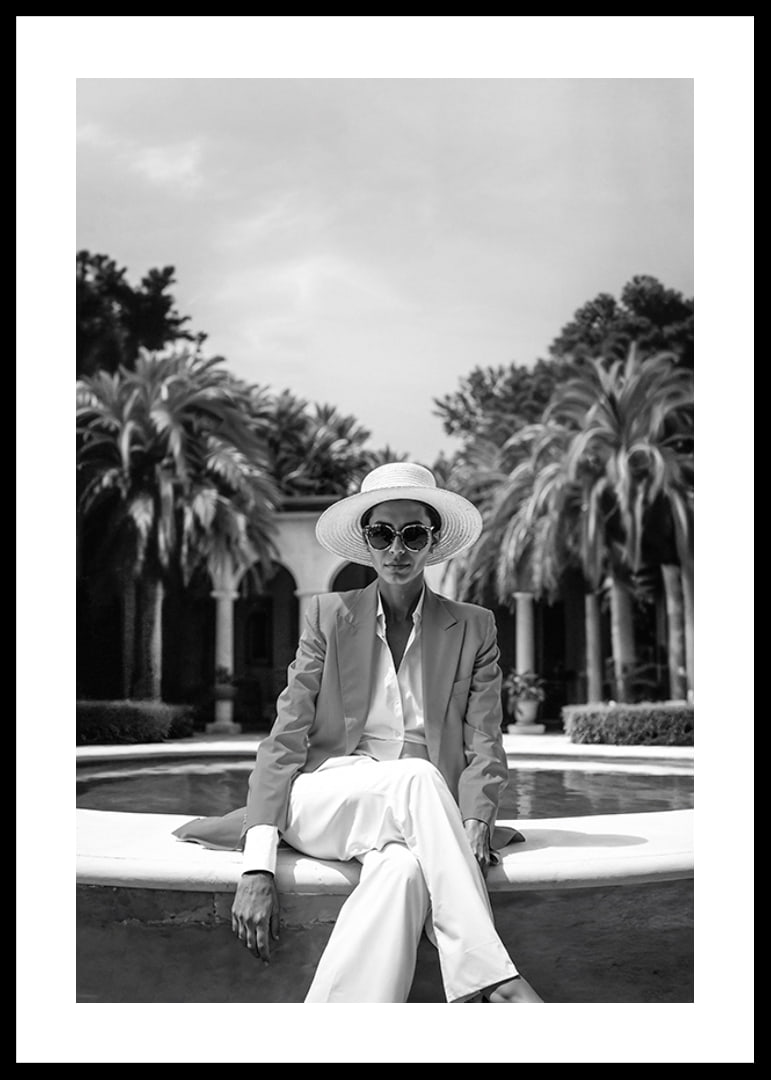 Black and white photo of woman in suit and sun hat by pool-12